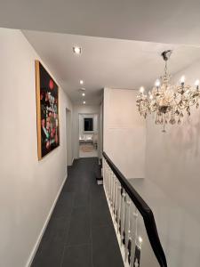 een gang met een kroonluchter en een gang met een trap bij Ferienhaus Lopezan House, Living in Hornberg