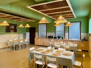 a dining room with tables and chairs and lights at Teka Guesthouse in Gherla
