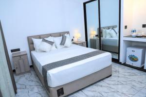 ネゴンボにあるThe Galaxy Airport Hotelの大きなベッドと大きな鏡のある寝室