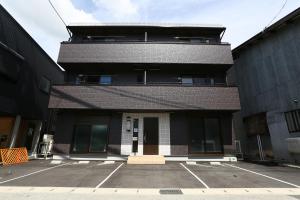 um prédio com um estacionamento na frente em Vieuno Hida Takayama em Takayama