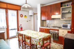 cocina con mesa con sillas y microondas en Downtown apartment by the beach, en Eraclea Mare 16 fotos más