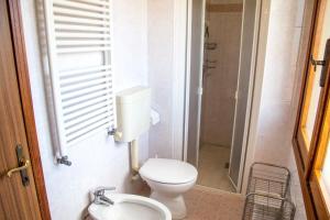 Un baño con inodoro, lavabo y ducha. en Downtown apartment by the beach, en Eraclea Mare
