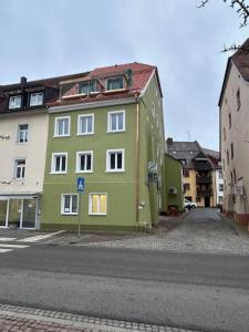 un bâtiment vert sur le côté d'une rue dans l'établissement Schwarzwald-Apartments-Vogel, à Hüfingen