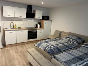 une chambre avec un lit et une cuisine dans l'établissement Schwarzwald-Apartments-Vogel, à Hüfingen 4 autres photos