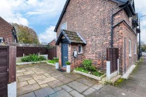 a brick house with a blue door on the side of it at Stylish 2BR Cottage Pet-Friendly with Free Parking in Partington