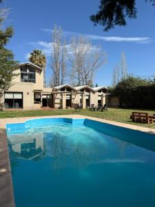 ein großer blauer Swimmingpool vor einem Haus in der Unterkunft Gran Casa con Piscina in Ciudad Lujan de Cuyo