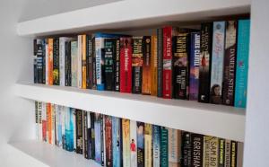 een boekenplank gevuld met veel boeken bij 7 Bed in Matlock Bath oc-n34368 in Cromford