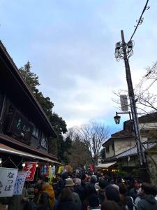 Eine Menschenmenge steht mit Schildern auf einer Straße in der Unterkunft Le Cave Troll ル カーブ トロル in Mitaka