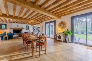 une salle à manger et un salon avec une table et des chaises dans l'établissement Le Bois Fleuri - 7500 m² de jardin, à La Couture-Boussey