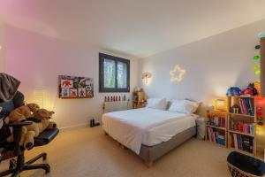 - une chambre avec un lit, une chaise et un ours en peluche dans l'établissement Le Bois Fleuri - 7500 m² de jardin, à La Couture-Boussey