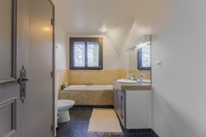 une salle de bain avec une baignoire, un lavabo et des toilettes dans l'établissement Le Bois Fleuri - 7500 m² de jardin, à La Couture-Boussey 9 autres photos