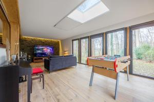 un salon avec une table de billard et une télévision dans l'établissement Le Bois Fleuri - 7500 m² de jardin, à La Couture-Boussey