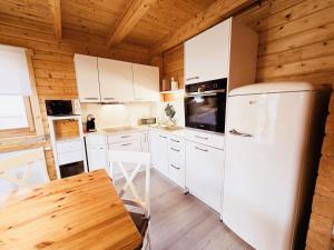 a kitchen with white appliances and a wooden ceiling at Ferienhaus Ostseeperle in Biendorf