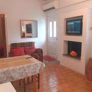 Traditional Stay near Lake Trichonida with Parking في Grammatikoú: غرفة معيشة مع أريكة ومدفأة