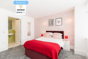 une chambre avec un grand lit recouvert d'une couverture rouge dans l'établissement Brindley 2BDR Apartment By Emporium Property Management Short Lets & Serviced Accommodation Birmingham On The 15th Floor Offering Panoramic City Views With Free WiFi, à Birmingham