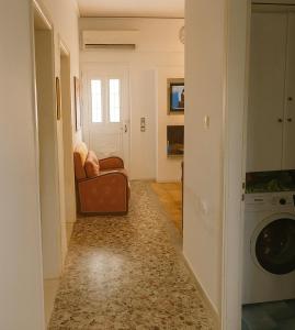 Traditional Stay near Lake Trichonida with Parking في Grammatikoú: غرفة معيشة مع أريكة وغسالة ملابس +7 صور