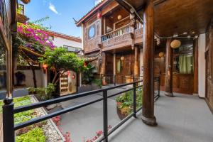 a balcony of a house with flowers and plants at 古城区瑾琳客栈 in Lijiang