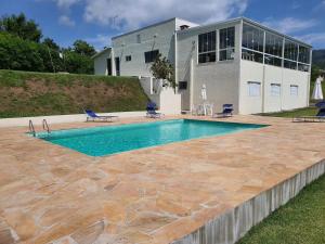 une piscine devant une maison dans l'établissement Sitio Recanto dos Passáros, à Caçapava