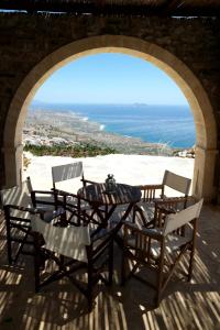 een tafel en stoelen op een patio met uitzicht op de oceaan bij Keramos Villa in Kerames