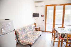 uma sala de estar com um sofá e uma mesa em Ground-floor haven just 350mt from the beach em Eraclea Mare