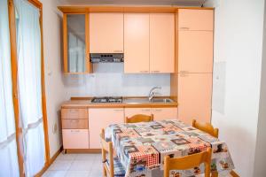 uma pequena cozinha com uma mesa e uma pia em Ground-floor haven just 350mt from the beach em Eraclea Mare