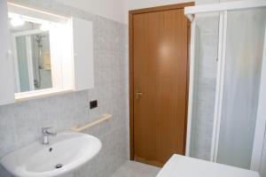 um banheiro com uma pia, um espelho e um chuveiro em Ground-floor haven just 350mt from the beach em Eraclea Mare mais 18 fotografias