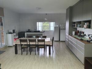 une cuisine avec une table et des chaises dans une pièce dans l'établissement Sitio Recanto dos Passáros, à Caçapava