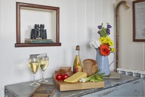 een tafel met wijnglazen en kaas en een vaas met bloemen bij 1 Bed in Masbury oc-l32718 in Oakhill
