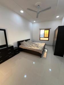 ein Schlafzimmer mit einem Bett, einer Kommode und einem Fernseher in der Unterkunft Your Cozy Stay in Bahrain in Jurdāb