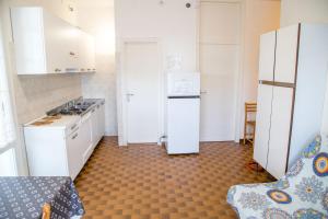 een keuken met witte kasten en een koelkast bij Apartment in pine forest near the beach in Eraclea Mare +31 foto's