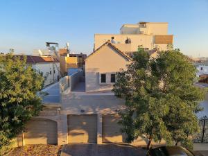 ein weißes Haus mit zwei Garagentoren in einer Stadt in der Unterkunft Your Cozy Stay in Bahrain in Jurdāb