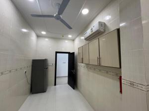 ein Bad mit einer Tür und einem Deckenventilator in der Unterkunft Your Cozy Stay in Bahrain in Jurdāb