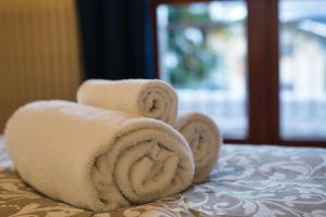 una pila di asciugamani appoggiata sopra un letto di Terrazza Alpina in centro Barzio a Barzio