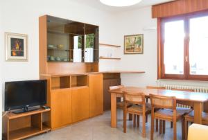 una cucina con tavolo da pranzo e TV di Terrazza Alpina in centro Barzio a Barzio Altre 23 foto