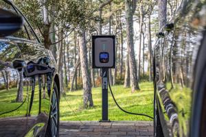 a car is hooked up to a charging station in a park at Villa Valpinia Luxury Villa in a Quiet Location with Pool, Sauna, Jacuzzi and Large Garden in Martinski +39 photos