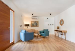 a living room with two blue chairs and a couch at Villa Valpinia Luxury Villa in a Quiet Location with Pool, Sauna, Jacuzzi and Large Garden in Martinski