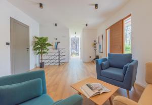 a living room with two blue chairs and a table at Villa Valpinia Luxury Villa in a Quiet Location with Pool, Sauna, Jacuzzi and Large Garden in Martinski