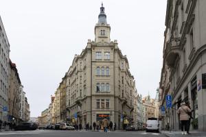 ein hohes Gebäude mit einem Uhrturm auf einer Stadtstraße in der Unterkunft Hostel Franz Kafka in Prag + 51 Fotos