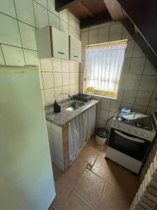 uma pequena cozinha com pia e fogão em Chalés Água de Coco em Boicucanga mais 24 fotografias