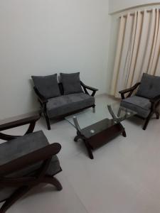 Una sala de estar con sofás y una mesa y sillas. en Chiakunja, en Sekerkalsi