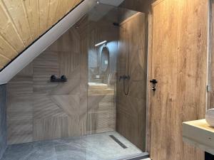 a shower with a glass door in a bathroom at Kolibe Doftana in Trăisteni +33 photos