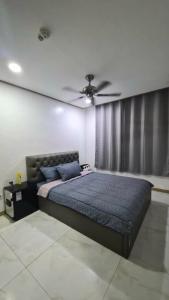 ein Schlafzimmer mit einem Bett mit Deckenventilator in der Unterkunft Stay at The Villages in Sampong + 4 Fotos