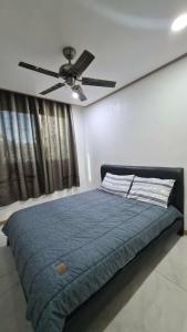 ein Schlafzimmer mit einem Bett mit Deckenventilator in der Unterkunft Stay at The Villages in Sampong