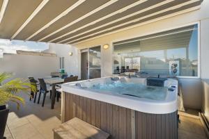 a jacuzzi tub in a living room with a table at Cherry Penthouse in Spinola Bay in St. Julianʼs +53 photos