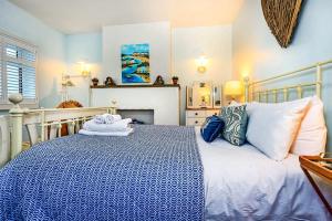 Schlafzimmer mit einem blauen und weißen Bett und einem Kamin in der Unterkunft Finest Retreats - No 3 Sandside in Whitby