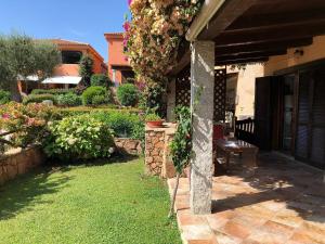 a patio of a house with a bench and flowers at Appartamenti Baia Smeralda in Santa Marinella +5 photos
