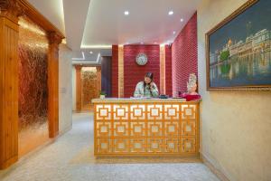 een vrouw aan een balie in een gebouw bij HOTEL RV GOLDEN 50 MTR FROM Golden temple in Amritsar