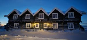 una casa in legno nella neve di notte di Langleiken a Sør-Fron