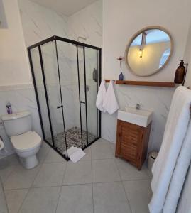 a bathroom with a shower and a toilet and a mirror at Cabana Beach Lodge in Cabo Conguiane