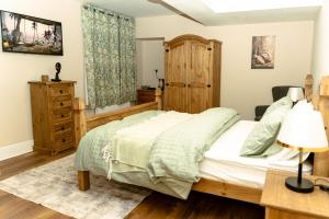 a bedroom with a bed and a dresser at The Sycamore Inn in Birch Vale